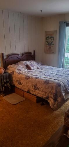 a bedroom with a bed with a blanket on it at A Stay In The Woods in Steger