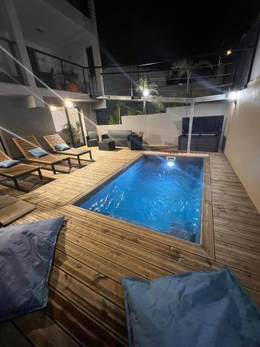 - une piscine sur la terrasse d'une maison la nuit dans l'établissement ZOT CHEZ ZOT, à Saint-Pierre