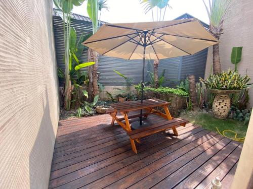 a wooden deck with a table and an umbrella at Xiadu Motel in Taichung