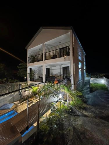 une maison avec une piscine en face de celle-ci la nuit dans l'établissement ZOT CHEZ ZOT, à Saint-Pierre