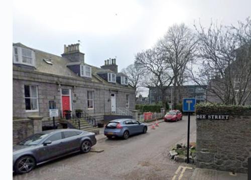 two cars parked in front of a stone house at Beulah Serviced bedrooms in Aberdeen