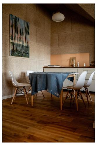 een eetkamer met een tafel en vier stoelen bij Pērlerada room in Engure