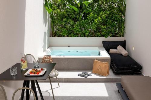 Whirlpool-Badewanne im Wohnzimmer mit Tisch in der Unterkunft Evanik Chic Hotel in Kalymnos