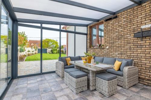 a patio with a table and chairs and a brick wall at Casa PERLA in Dunajská Streda