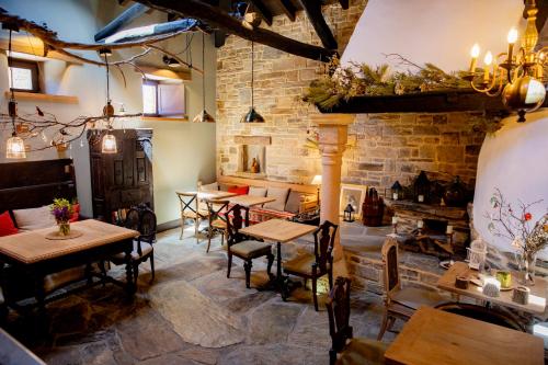 a restaurant with tables and chairs and a brick wall at Via Avis in Santa Catalina de Somoza