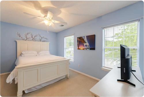 a bedroom with a white bed and a ceiling fan at The Cozy Hidden Gem in Charleston