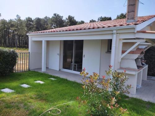 une petite maison blanche avec une cour dans l'établissement MONTALIVET STUDIO MEZZANINE, à Vendays-Montalivet