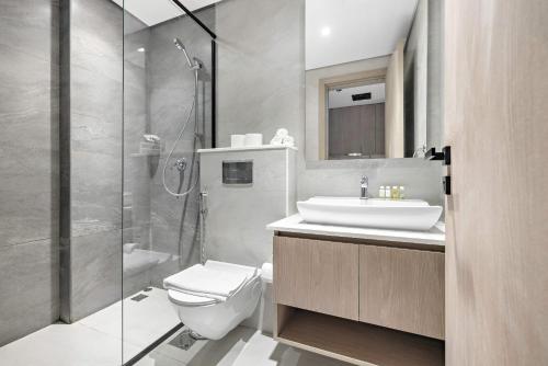 y baño con aseo, lavabo y ducha. en Stylish Studio in New residence with pool and gym en Dubái