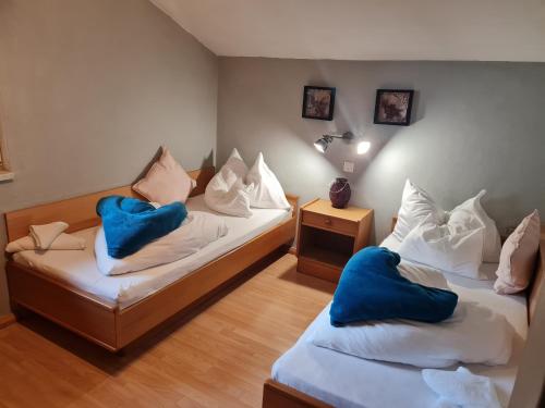 ノイシュティフト・イム・シュトゥーバイタールにあるApartments Grillstubeの青い枕が備わる客室内のベッド2台