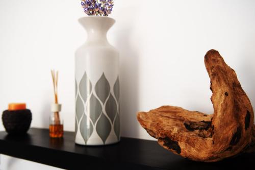 a vase and a piece of wood on a table at Savona Sea House Apartment in Savona