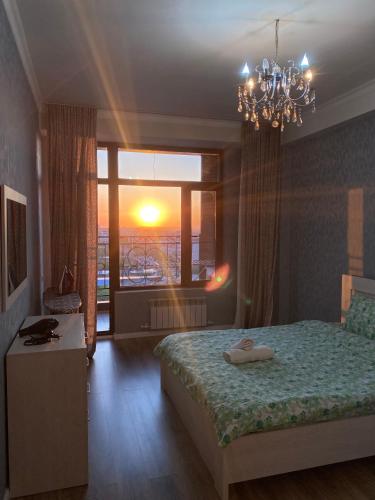 a bedroom with a bed and a window and a chandelier at Резиденс in Bishkek