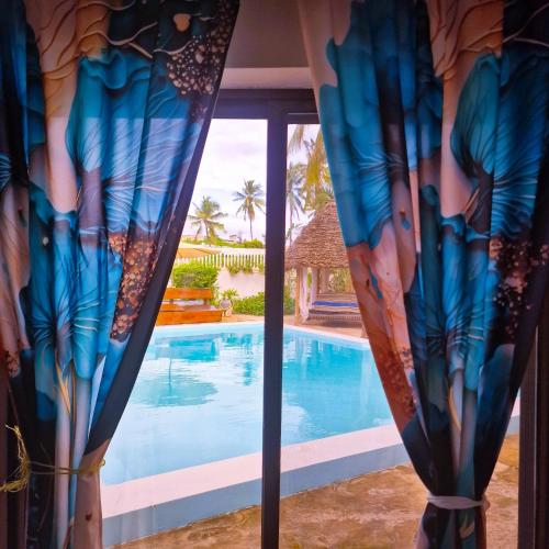 a view of a swimming pool from a window at TIANDE Boutique Hotel in Pwani Mchangani