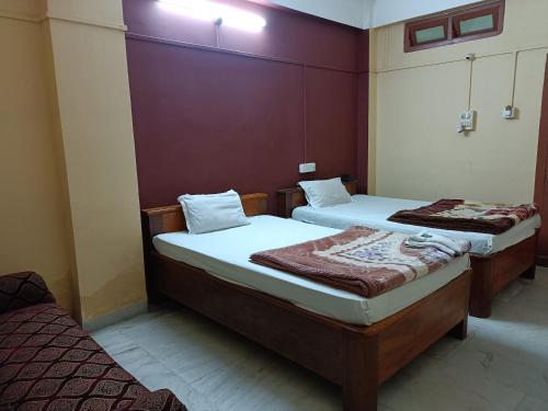 two twin beds in a room with at Hotel Yuvraj Palace in Chutiyā Mīrigaon