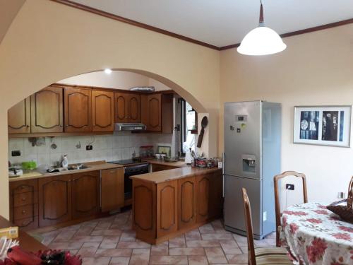 a kitchen with wooden cabinets and a stainless steel refrigerator at Villa ne Vlore in Vlorë
