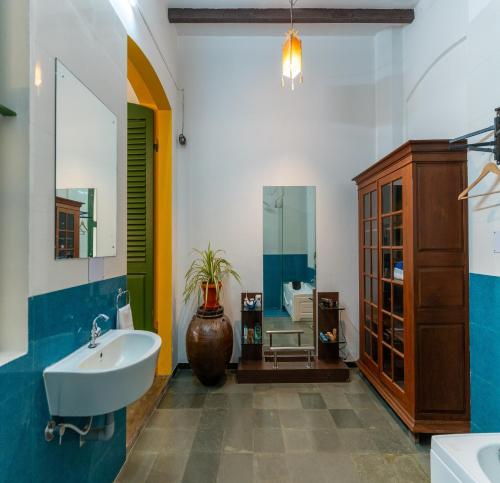 uma casa de banho com um lavatório e um espelho em Luigi Villa em Pondicherry