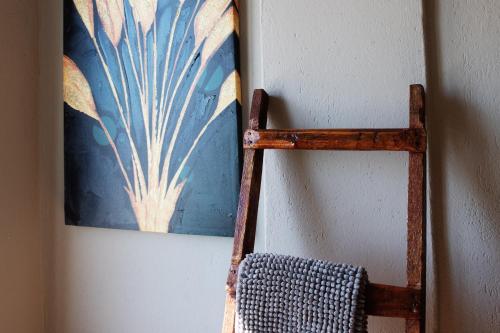 a wooden towel rack next to a wall with a painting at Savona Sea House Apartment in Savona