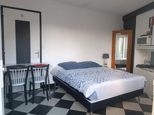 1 dormitorio con 1 cama, mesa y sillas en Chambre privative à st remy en mauges, en La Chaussaire