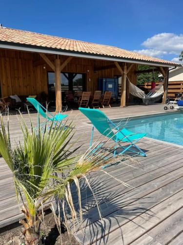 quelques chaises bleues posées sur une terrasse à côté d'une piscine dans l'établissement Maison typique proche bassin Arcachon, à Salles