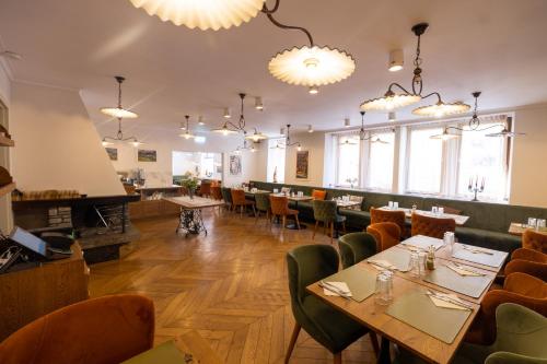 a dining room with tables and chairs and chandeliers at Hotel Radetzky in Sankt Gilgen