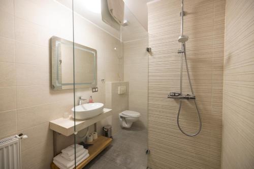 a bathroom with a sink and a toilet and a shower at Hotel Radetzky in Sankt Gilgen