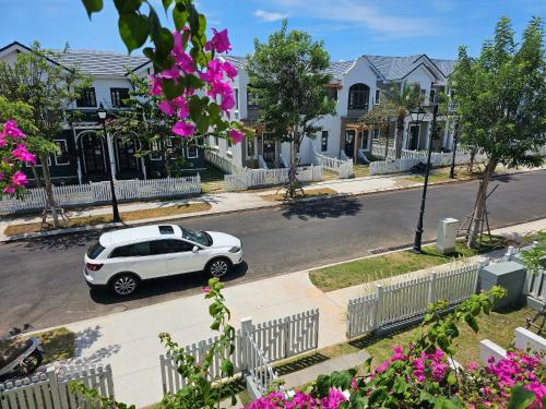 a white car parked on a street with houses at Holiday Villa Novaworld Phan Thiet in Phan Thiet