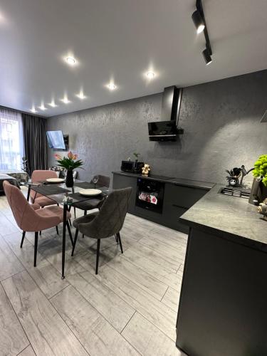 Il comprend une cuisine et un salon avec une table et des chaises. dans l'établissement Апартаменты в Алматы, à Almaty