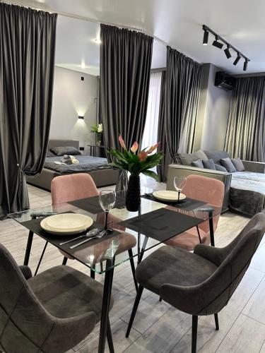 - un salon avec une table, des chaises et un canapé dans l'établissement Апартаменты в Алматы, à Almaty