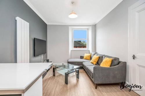 a living room with a couch and a tv at Lilas Suite Abbeyhill - 1BR-1BA 5 Mins to Meadowbank Shopping by Bonjour Residences Edinburgh in Edinburgh