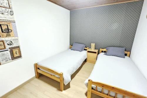 une chambre avec deux lits dans une pièce dans l'établissement Maison berrichonne 4 pers, à Niherne