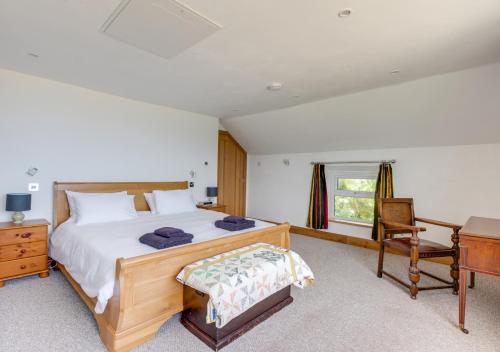 a bedroom with a bed and a desk and a chair at Cyfannedd Uchaf in Fairbourne