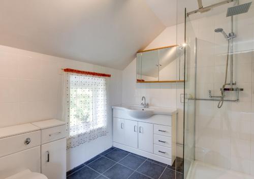 a bathroom with a sink and a shower at Cyfannedd Uchaf in Fairbourne