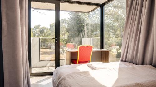 - une chambre avec un lit, un bureau et une fenêtre dans l'établissement Heritage Holiday House No.191, à Christmas Hills