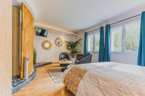 une chambre avec un lit, une chaise et des fenêtres dans l'établissement Les chantrines, à Chessy