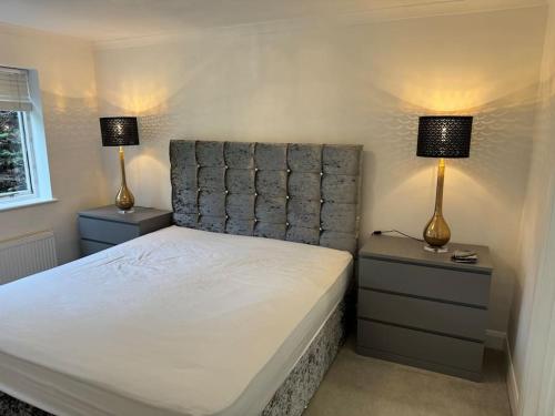 - une chambre avec un lit et 2 lampes sur les tables de chevet dans l'établissement Weybridge garden cottage, à Weybridge