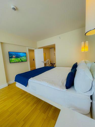 een slaapkamer met een groot wit bed met blauwe kussens bij Luxury Batumi Hotel in Batoemi