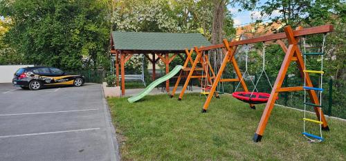 a park with a playground with a slide and a car at Lux Apartmani Novi Park in Vrdnik