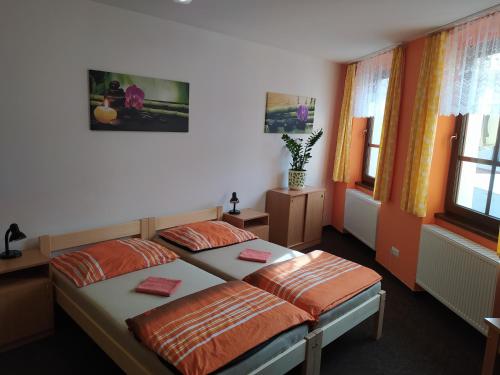 2 camas en una habitación con 2 ventanas en Penzion a restaurace U Pošů en Volyně
