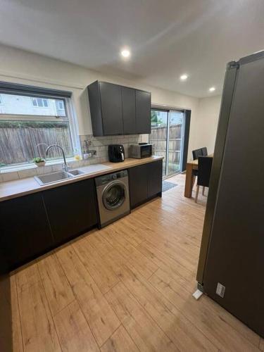 a kitchen with a sink and a washing machine at 3 Bedroom House - Ideal for Contractors - Sleeps 6 in Runcorn