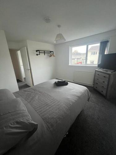 a bedroom with a bed and a window and a dresser at 3 Bedroom House - Ideal for Contractors - Sleeps 6 in Runcorn