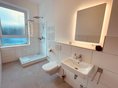 biała łazienka z toaletą i umywalką w obiekcie Fährhaus Kirschenland w mieście Jork