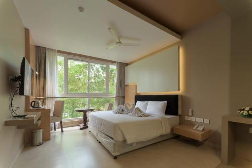 a bedroom with a bed and a large window at Vythiri Village in Vythiri