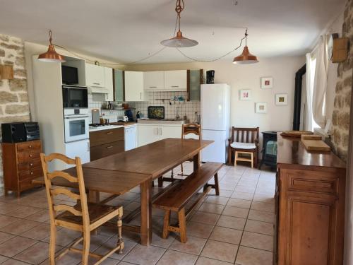 a kitchen with a wooden table and a dining room at Gîte La Grange in Saint-Laurent-dʼOlt