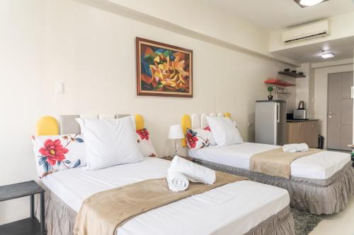 Cette chambre comprend deux lits et un réfrigérateur. dans l'établissement Wind Residence 4, à Tagaytay