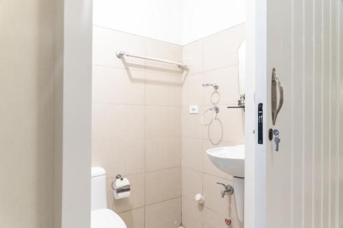 La salle de bains blanche est pourvue de toilettes et d'un lavabo. dans l'établissement Wind Residence 4, à Tagaytay
