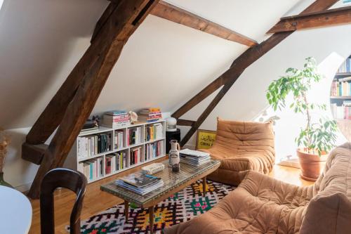 a living room with a book shelf with books at Cozy 55 m close to the Seine in Saint-Denis