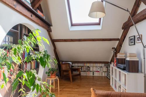an attic room with bookshelves and a window at Cozy 55 m close to the Seine in Saint-Denis