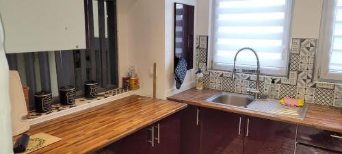 una cucina con lavandino e bancone in legno di Belle appartement ensoleille a Boulogne-sur-Mer