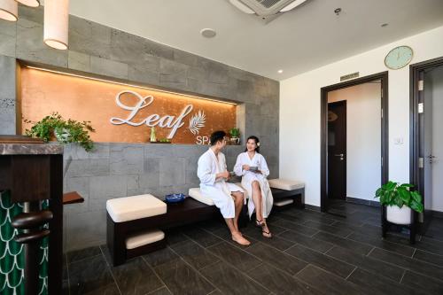 two people sitting on a bench in a lobby at Emerald Ho Tram Resort in Ho Tram