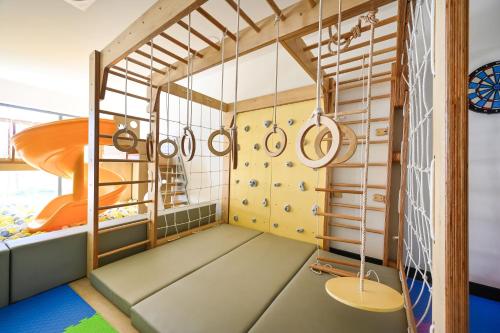 a childrens room with a climbing wall and a slide at Emerald Ho Tram Resort in Ho Tram
