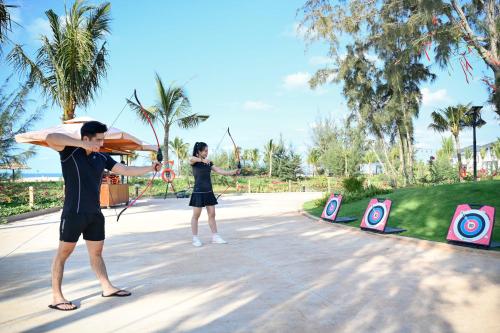 two people are playing a game of archery at Emerald Ho Tram Resort in Ho Tram